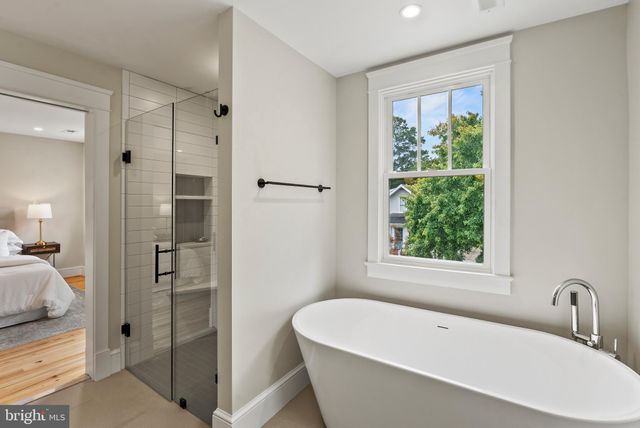a white bath tub sitting next to a shower