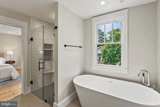 a white bath tub sitting next to a shower