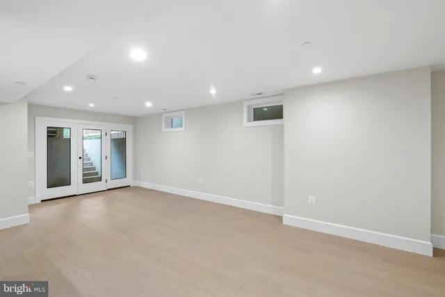 an empty room with entrance and windows