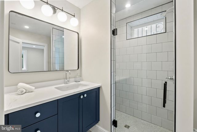 a bathroom with a double vanity sink mirror and shower
