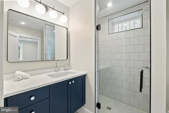 a bathroom with a double vanity sink mirror and shower