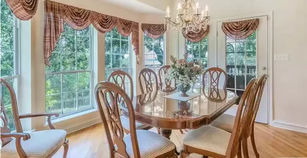 a view of a dining room with furniture a chandelier and wooden floor