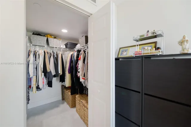 a view of walk in closet with clothes and shoes