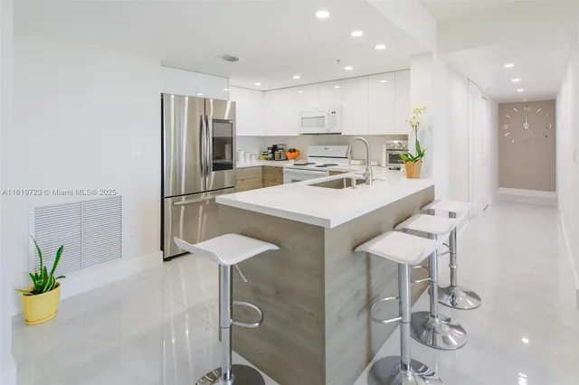 a kitchen with a sink a refrigerator and wooden floor