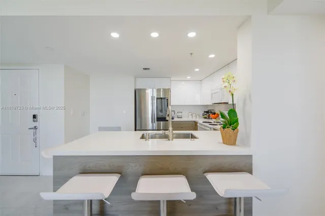 a kitchen with stainless steel appliances a table and chairs in it