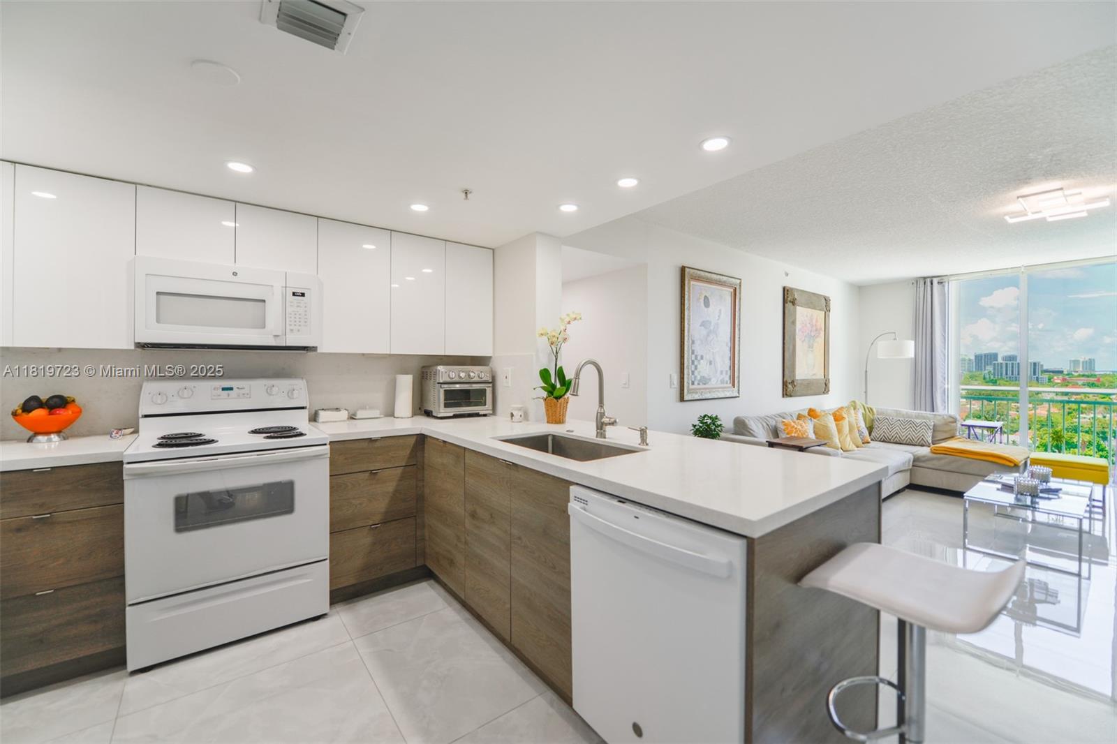 3000 Coral Way, Unit 1208 Miami, FL 33145 - Photo 10 of 35 a kitchen with a sink stainless steel appliances and white cabinets