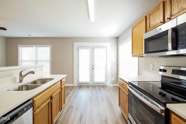 a kitchen with sink a microwave and cabinets