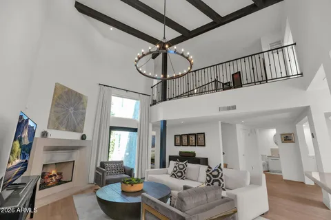 a living room with furniture a fireplace and a chandelier