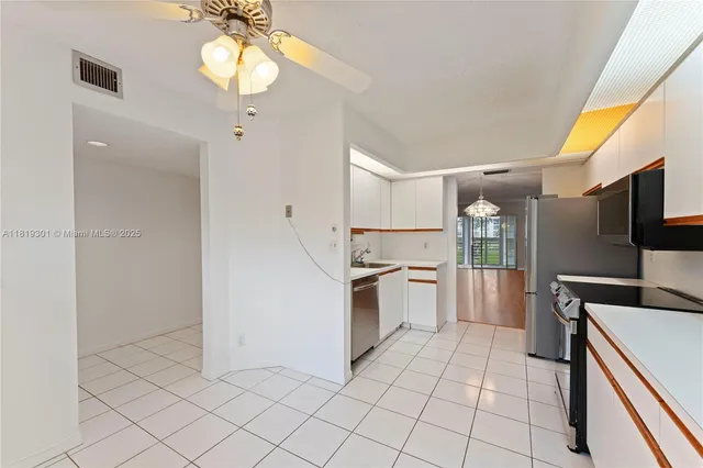 a kitchen with granite countertop a refrigerator and a stove top oven