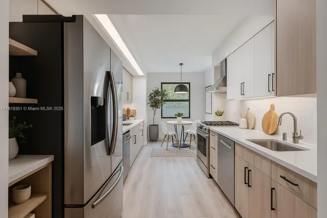 a large kitchen with a refrigerator a sink a stove and cabinets