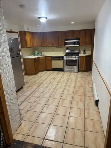 a kitchen with stainless steel appliances a stove a sink and a refrigerator