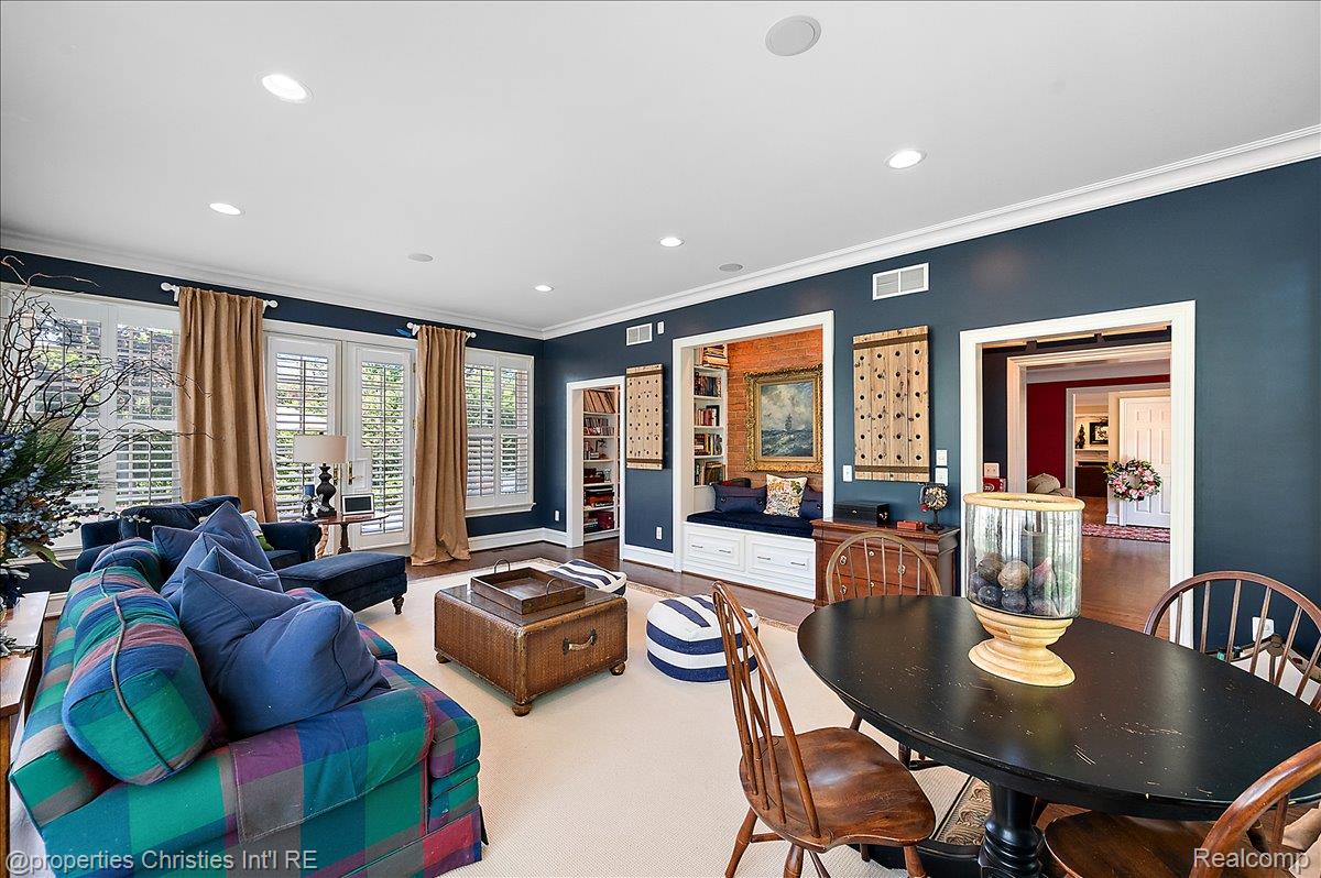 135 Clifton Road Bloomfield Hills, MI 48301 - Photo 14 of 77 Spacious living area featuring dark blue walls, white trim, and multiple large windows with plantation shutters