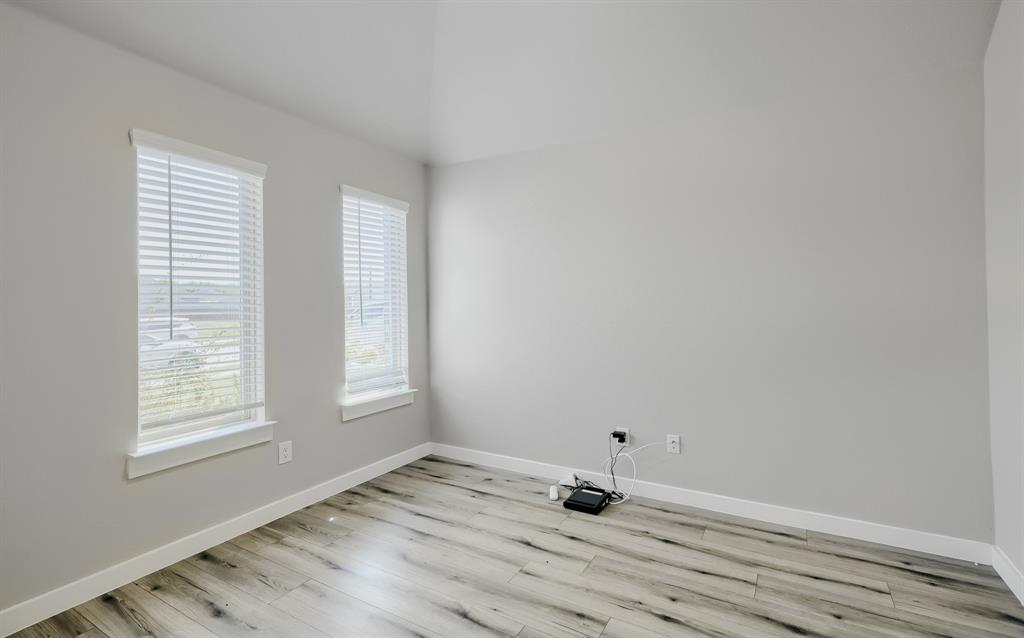 114 Mandarin Street Forney, TX 75126 - Photo 8 of 11 Room featuring wood-finish flooring, light grey painted walls, white baseboards, and two windows with white blinds