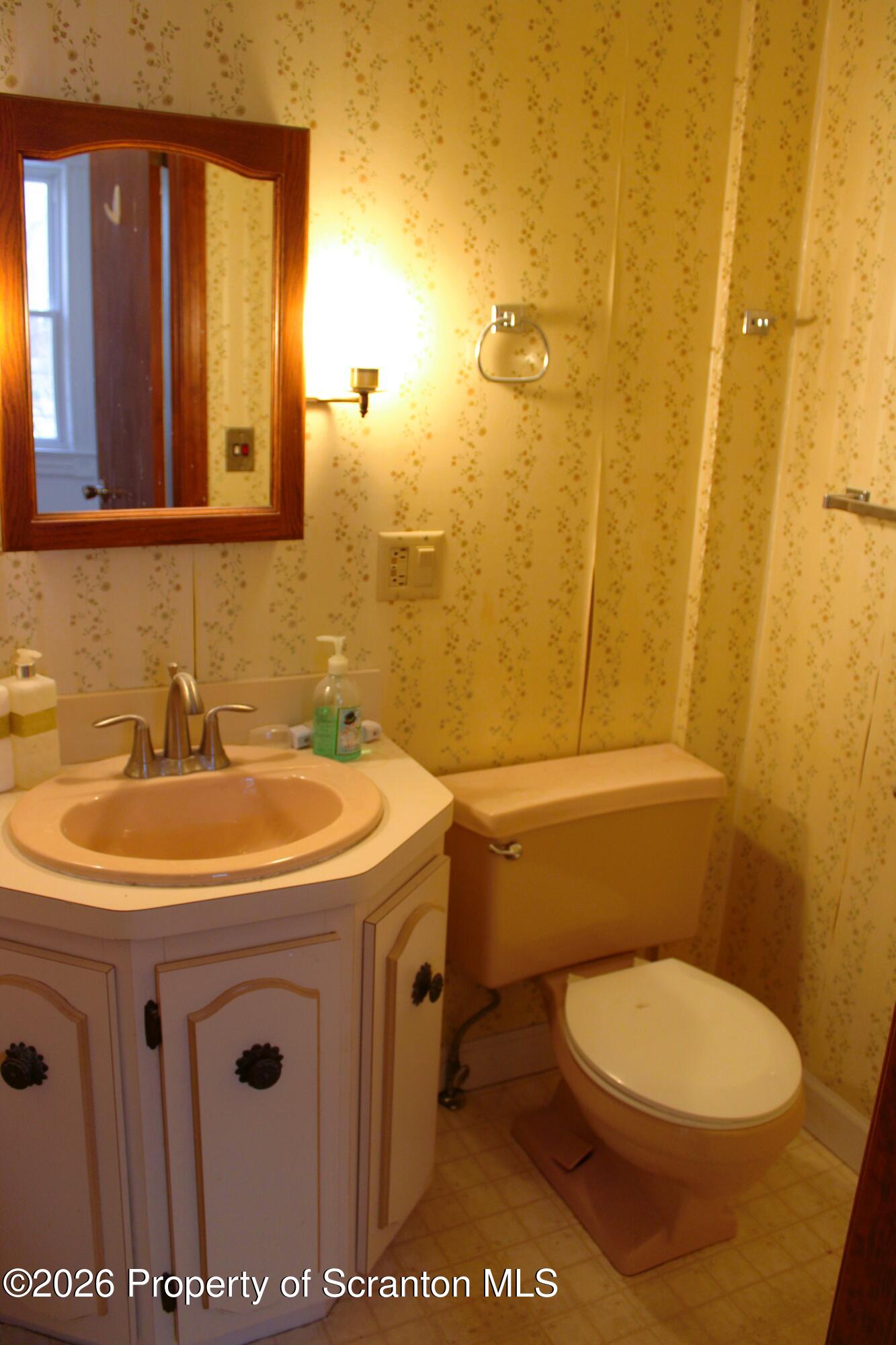 1329-1331 Oram Street Scranton, PA 18504 - Photo 18 of 29 a bathroom with a sink a toilet and mirror