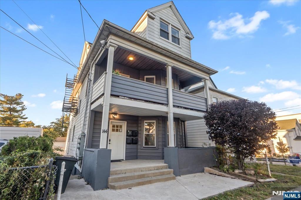 a view of a house with a small yard and potted plants
