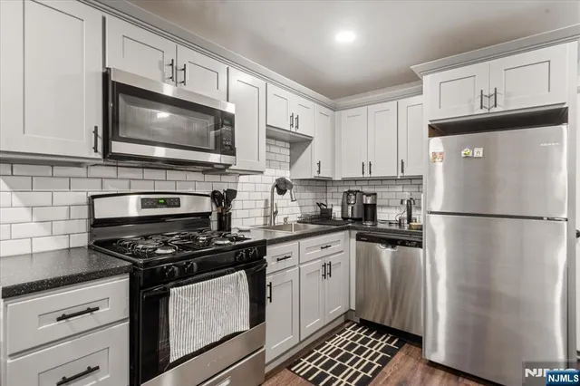 a kitchen with stainless steel appliances a refrigerator stove and microwave