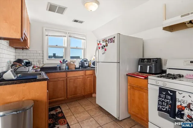 a kitchen with a refrigerator a stove top oven a sink and dishwasher
