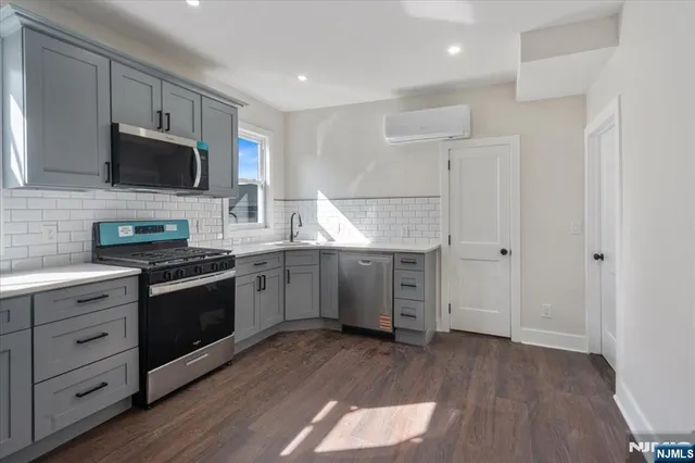 a kitchen with stainless steel appliances granite countertop a stove a sink and a refrigerator