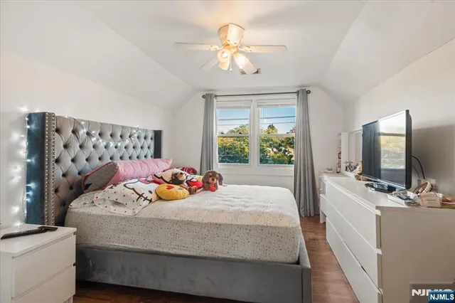 a bedroom with a bed and a flat tv screen on dresser