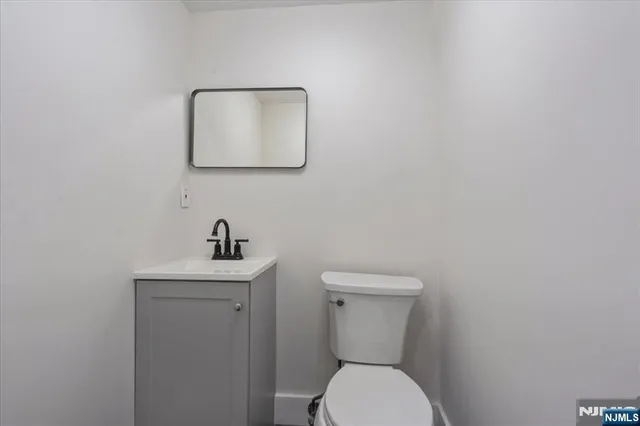a bathroom with a toilet a sink and mirror