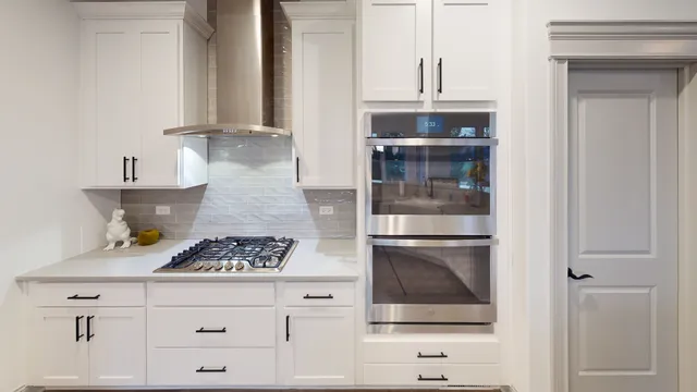 a kitchen with granite countertop white cabinets and white appliances