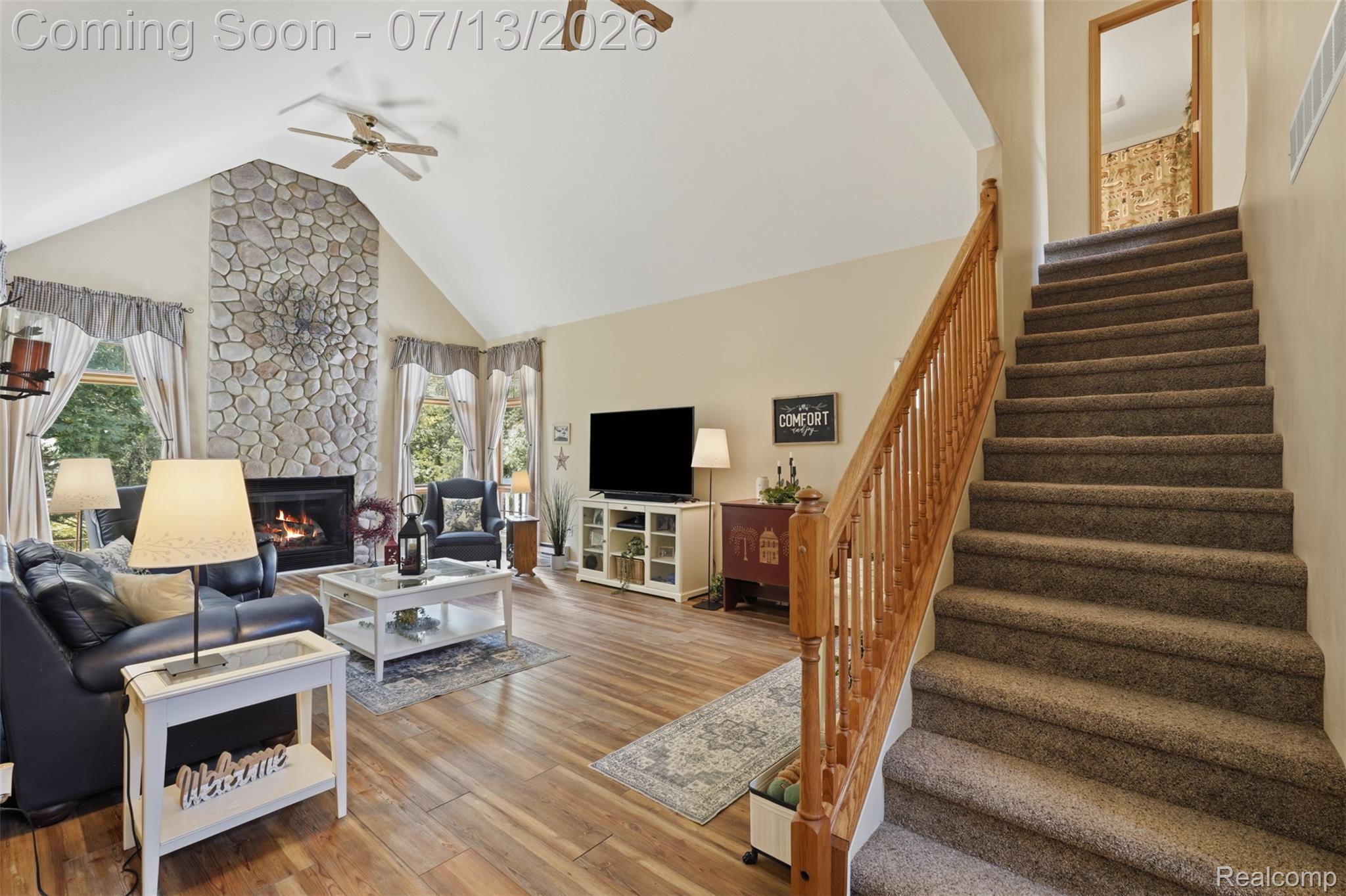 10525 Antcliff Road Brooklyn, MI 49230 - Photo 8 of 80 Spacious living area featuring a stone fireplace, vaulted ceiling, and peaceful views of nature