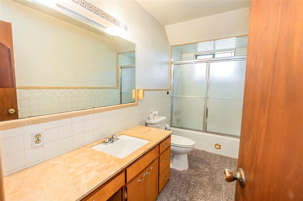 722 Storey Road Nocona, TX 76255 - Photo 19 of 40 a bathroom with a sink a toilet and shower