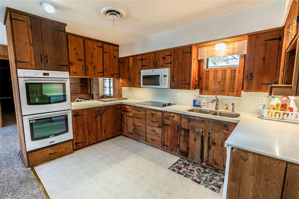 722 Storey Road Nocona, TX 76255 - Photo 23 of 40 a kitchen with stainless steel appliances granite countertop a stove a sink dishwasher and a microwave oven with cabinets