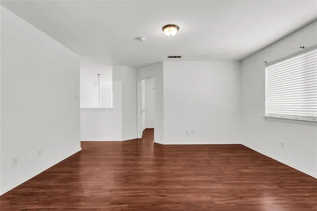 a view of room with window and wooden floor