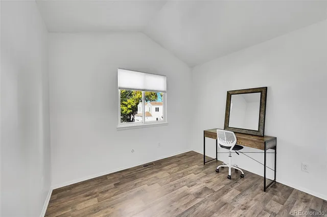 a room with a wooden floor and a window