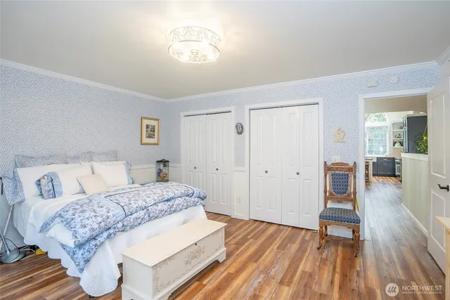 a spacious bedroom with a bed and a wooden floor