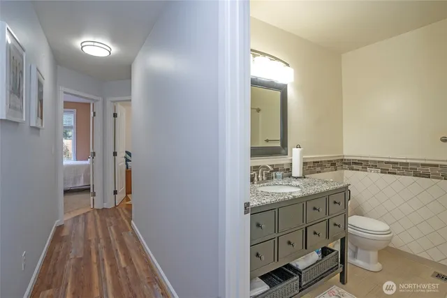 a bathroom with a granite countertop toilet sink and mirror