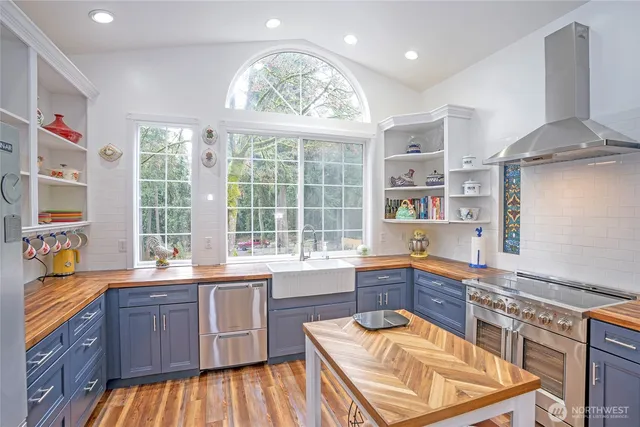 a kitchen with stainless steel appliances granite countertop a sink and wooden cabinets