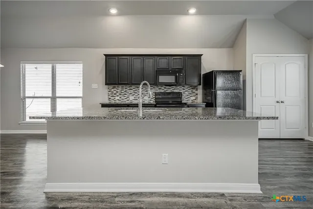 a kitchen with stainless steel appliances a sink and a refrigerator