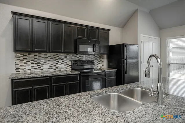 a kitchen with a sink stove and refrigerator