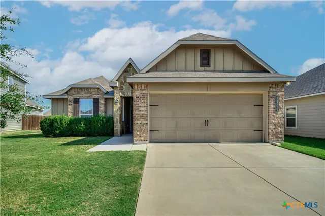 a front view of a house with a yard and garage