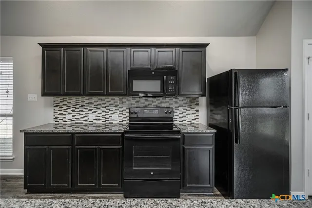 a kitchen with a refrigerator and cabinets