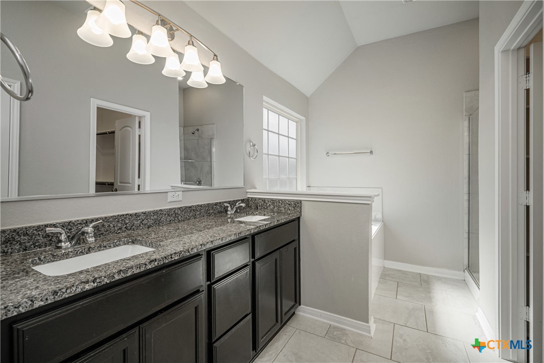8109 Northgate Loop Temple, TX 76502 - Photo 25 of 35 a bathroom with a granite countertop sink a mirror and a shower
