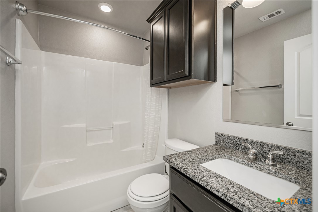 8109 Northgate Loop Temple, TX 76502 - Photo 32 of 35 a bathroom with a granite countertop sink a toilet and shower