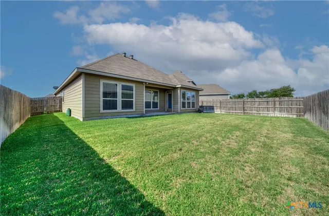 a view of a house with a yard and sitting area