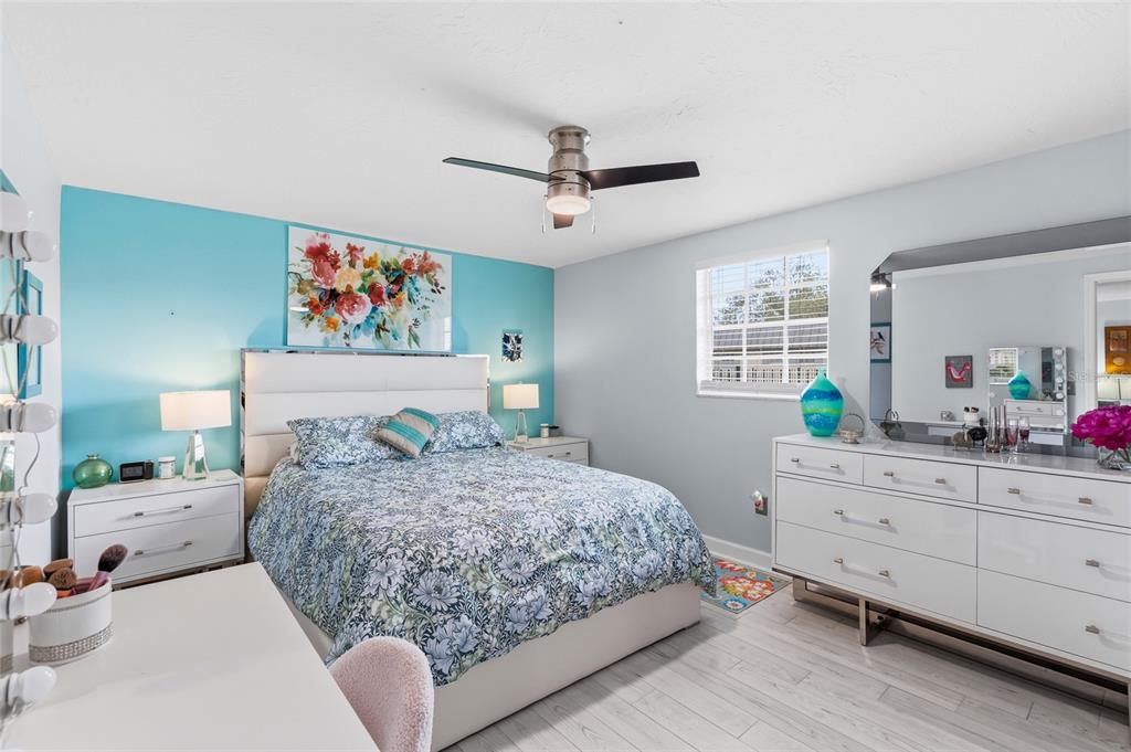 4467 Rustic Drive New Port Richey, FL 34652 - Photo 16 of 44 a bedroom with a large bed and a chandelier