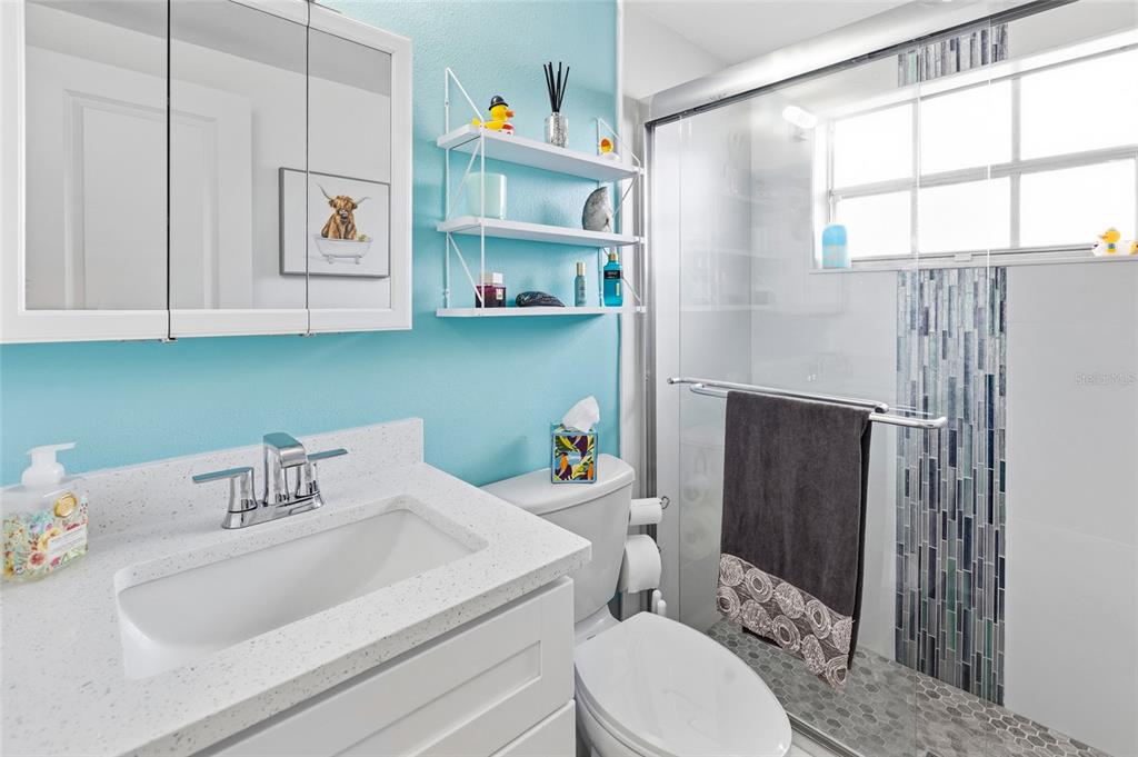 4467 Rustic Drive New Port Richey, FL 34652 - Photo 22 of 44 a bathroom with a sink a toilet and a shower curtain