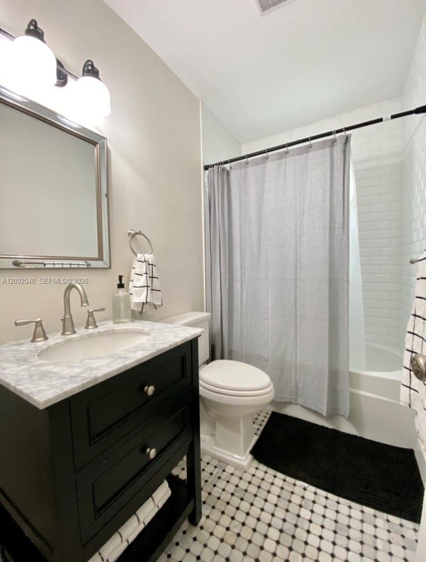 4619 Southwest 10th Street Miami, FL 33134 - Photo 22 of 30 a bathroom with a sink a toilet a mirror and shower
