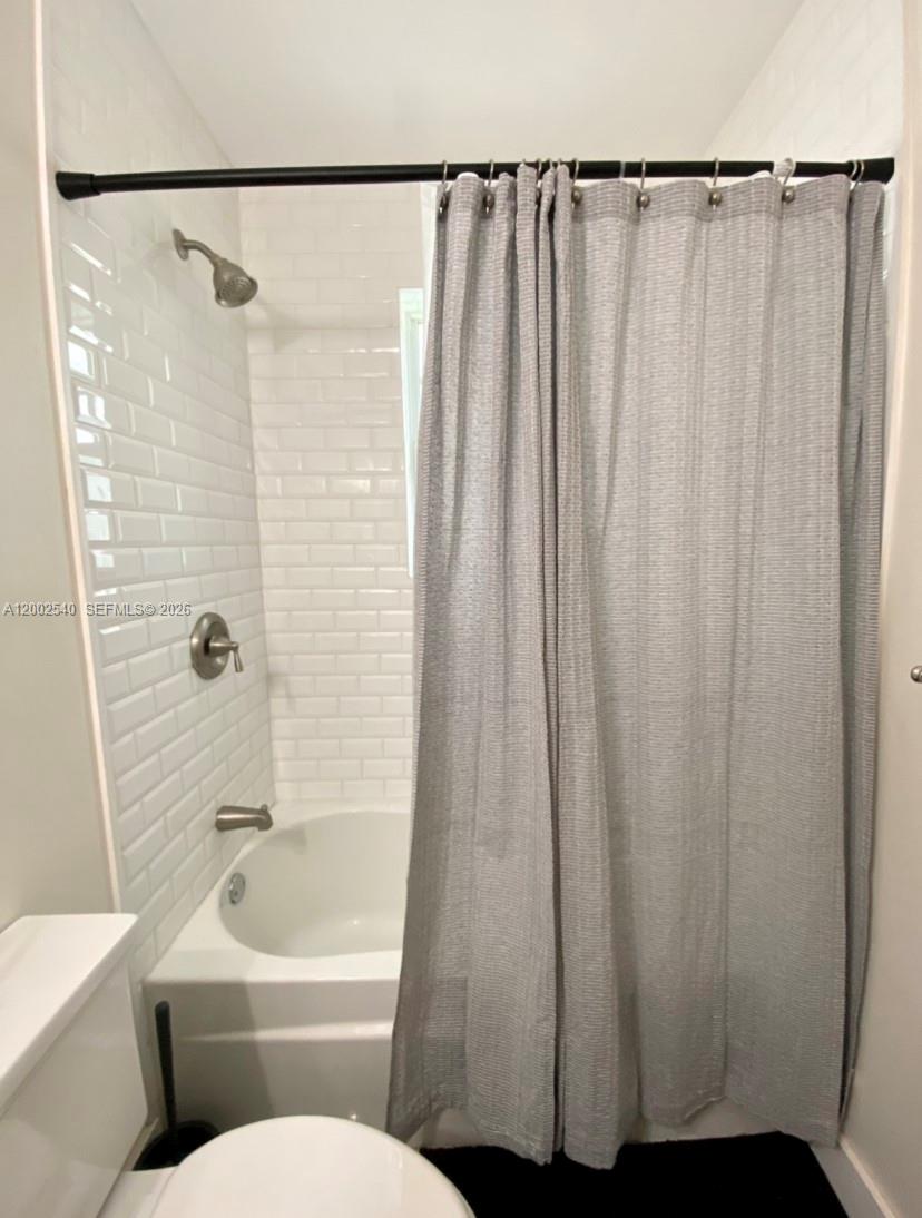 4619 Southwest 10th Street Miami, FL 33134 - Photo 23 of 30 a bathroom with a shower curtain and a toilet