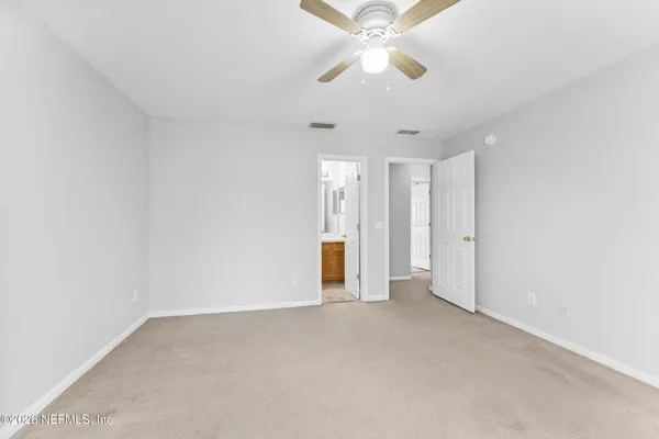 an empty room with a ceiling fan and a window