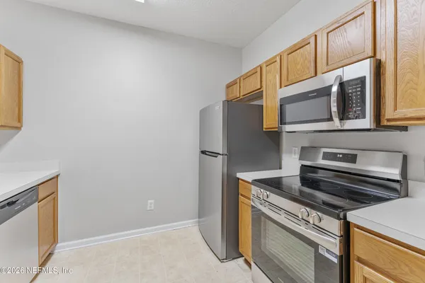 a kitchen with stainless steel appliances a stove microwave and refrigerator