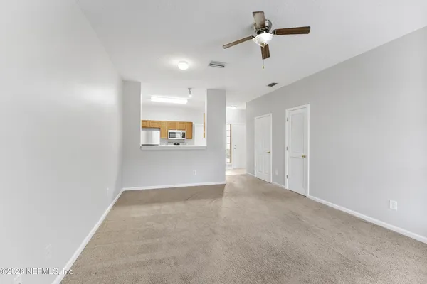an empty room with a ceiling fan and a window