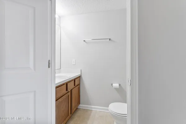 a bathroom with a granite countertop sink and toilet