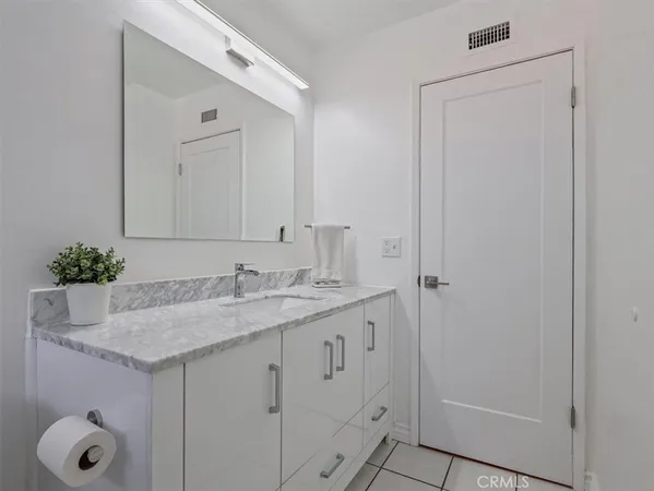 a bathroom with a granite countertop sink and a mirror