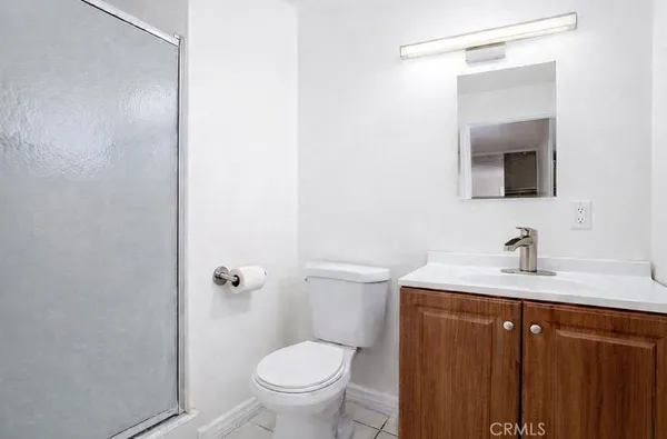 a bathroom with a granite countertop sink toilet and mirror